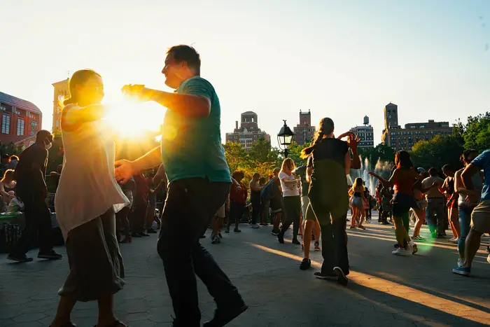 A photo of people salsa dancing in Washington Square Park